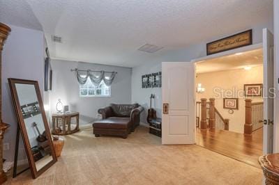 living area with carpet floors and a textured ceiling