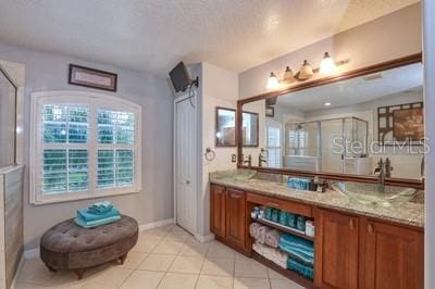 bathroom with tile patterned floors, vanity, and walk in shower