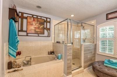 bathroom with tile patterned floors, a textured ceiling, and shower with separate bathtub