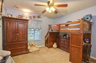 bedroom with a textured ceiling and light carpet