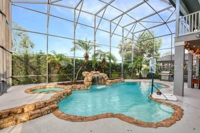 view of swimming pool with an in ground hot tub, a patio, and a lanai