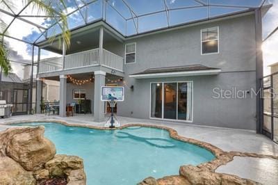 back of property with a patio, glass enclosure, and a balcony