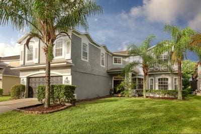 view of front of house featuring stucco siding, driveway, an attached garage, and a front lawn
