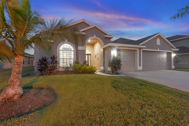 view of front of home with a lawn and a garage