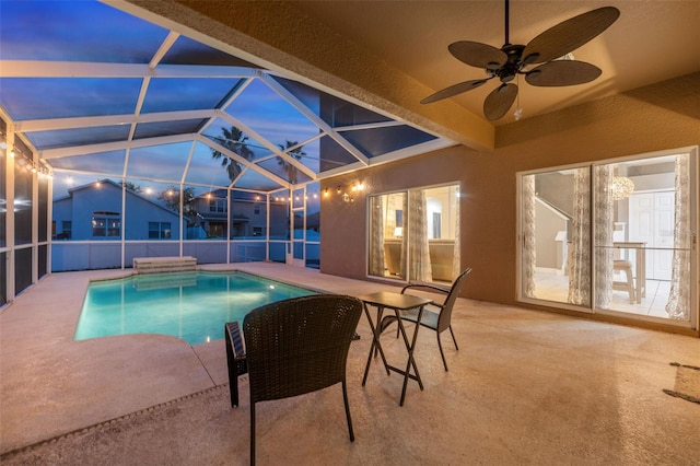 pool at dusk with a patio, a lanai, and ceiling fan