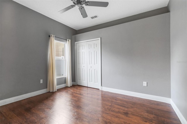 unfurnished bedroom with a closet, ceiling fan, and dark hardwood / wood-style floors