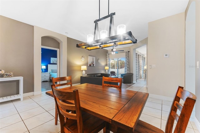 tiled dining area with ceiling fan with notable chandelier