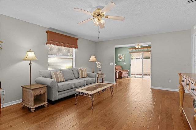 living room with hardwood / wood-style floors, a wealth of natural light, and ceiling fan