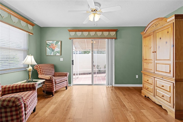 sitting room featuring a textured ceiling, light hardwood / wood-style flooring, and ceiling fan