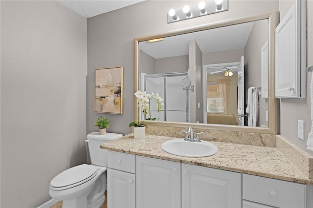 bathroom with vanity, a textured ceiling, toilet, ceiling fan, and a shower with shower door