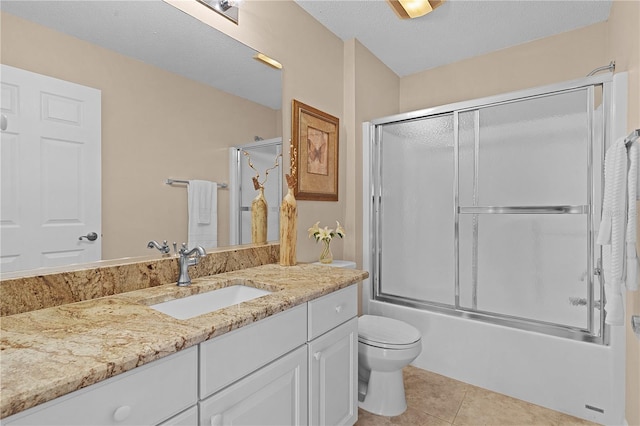 full bathroom featuring tile patterned flooring, a textured ceiling, shower / bath combination with glass door, vanity, and toilet