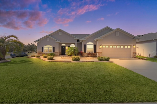 9702 Pepper Tree Pl, Wildwood, FL 34785 - view of front of house featuring a yard, concrete driveway, an attached garage, stone siding, and stucco siding