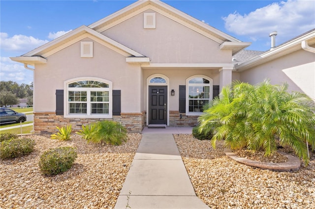 9702 Pepper Tree Pl, Wildwood, FL 34785 - view of front of house featuring stone siding and stucco siding