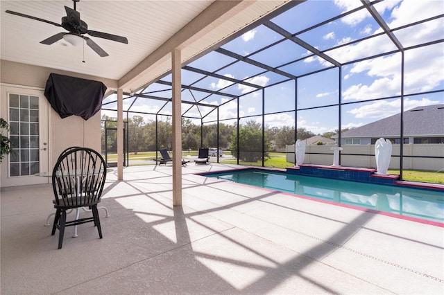 view of swimming pool featuring a patio, glass enclosure, and ceiling fan