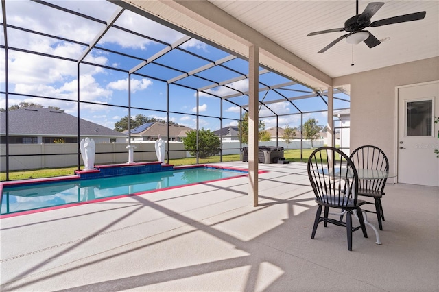 view of swimming pool with a patio, ceiling fan, and glass enclosure