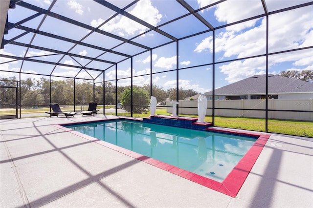 view of pool with a patio, glass enclosure, and a yard