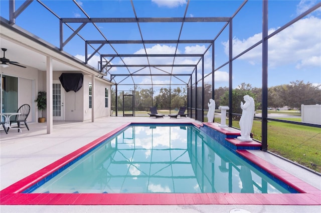 view of swimming pool with a yard, a patio area, glass enclosure, and ceiling fan