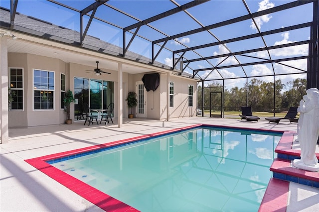 view of pool featuring a patio area, glass enclosure, and ceiling fan