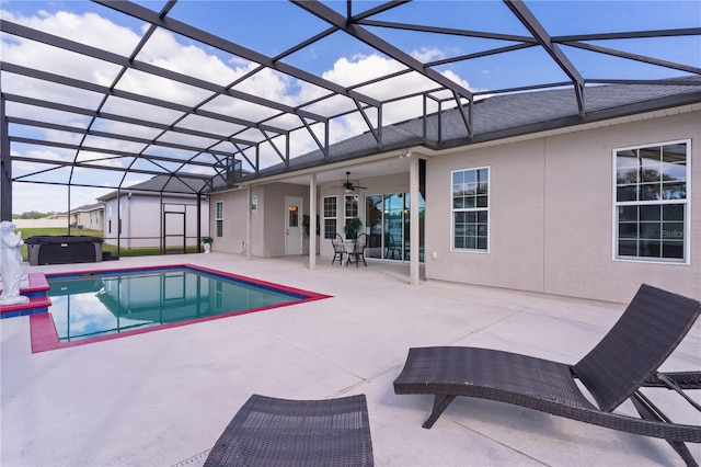 view of pool with a jacuzzi, a patio area, glass enclosure, and ceiling fan