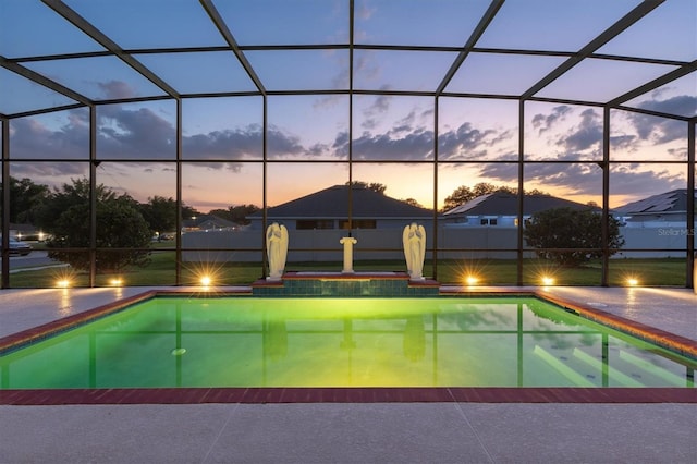 pool at dusk with a patio area and glass enclosure