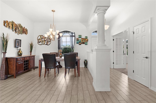 dining space featuring ornate columns, a notable chandelier, and light wood-type flooring