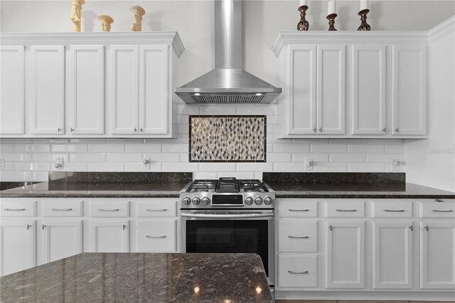 kitchen featuring white cabinets, wall chimney range hood, and gas range