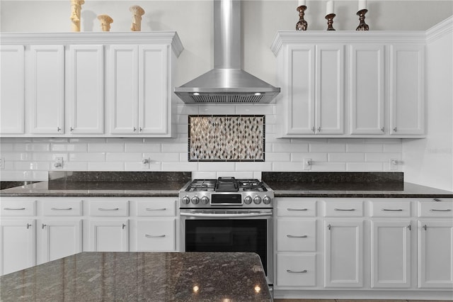 9702 Pepper Tree Pl, Wildwood, FL 34785 - kitchen featuring white cabinetry, decorative backsplash, stainless steel gas range oven, and wall chimney exhaust hood