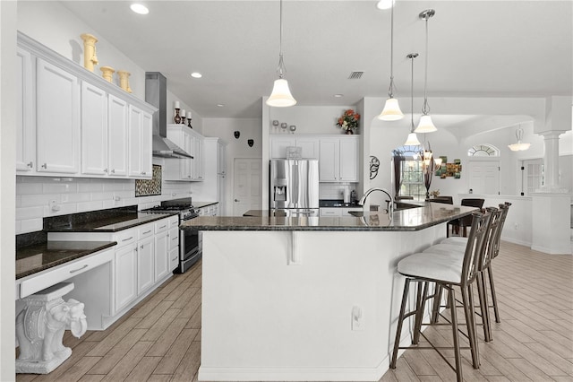 9702 Pepper Tree Pl, Wildwood, FL 34785 - kitchen with decorative backsplash, wall chimney exhaust hood, appliances with stainless steel finishes, and wood finish floors