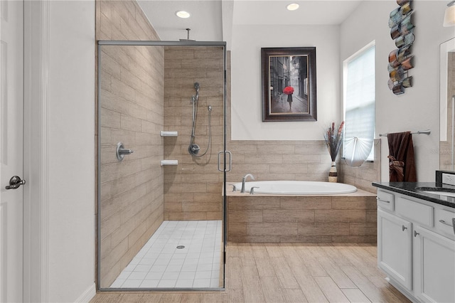 bathroom with vanity, plus walk in shower, and wood-type flooring