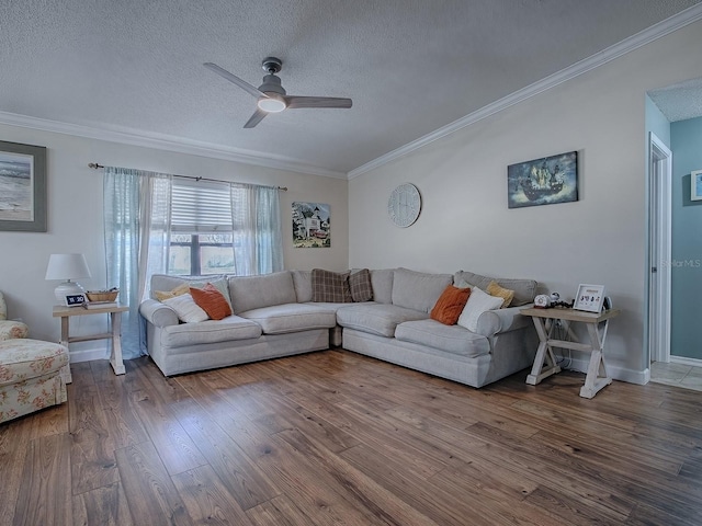 living room with ceiling fan, wood-type flooring, a textured ceiling, and ornamental molding