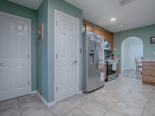 kitchen with appliances with stainless steel finishes and light tile patterned floors