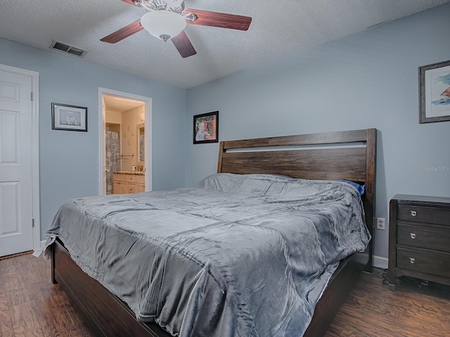 bedroom featuring dark wood-type flooring, ceiling fan, a textured ceiling, and ensuite bathroom