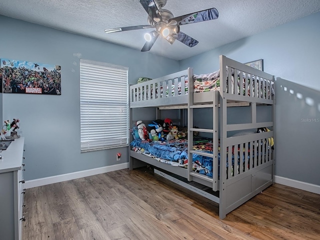 bedroom featuring hardwood / wood-style floors, a textured ceiling, and ceiling fan