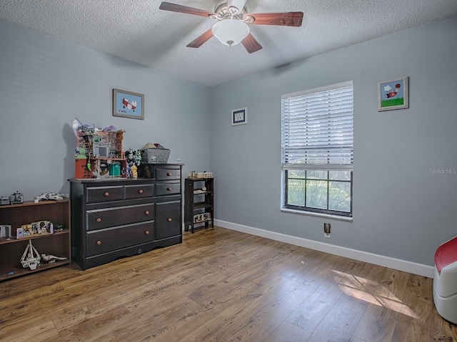 bedroom featuring ceiling fan, a textured ceiling, and hardwood / wood-style floors