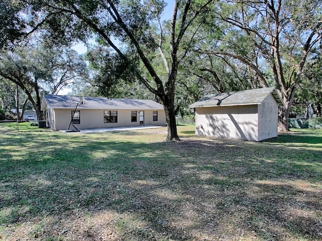 view of yard featuring a storage unit and a patio