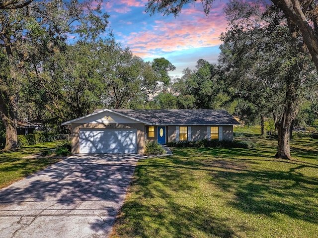 single story home featuring a yard and a garage