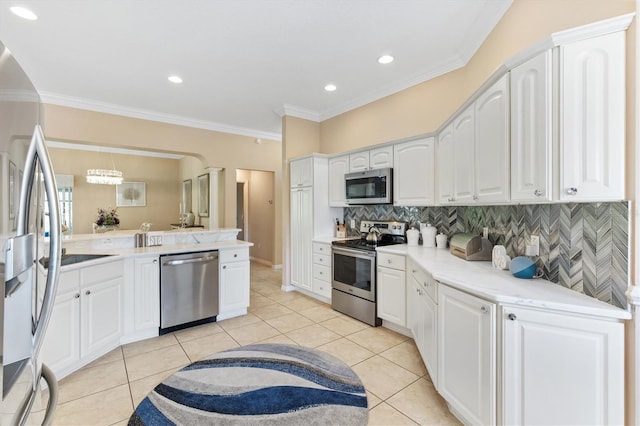 kitchen with kitchen peninsula, white cabinets, crown molding, and stainless steel appliances