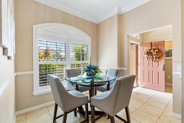 dining space featuring light tile patterned floors and crown molding