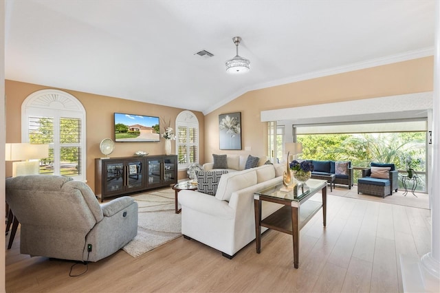 living room with crown molding, a healthy amount of sunlight, lofted ceiling, and light wood-type flooring