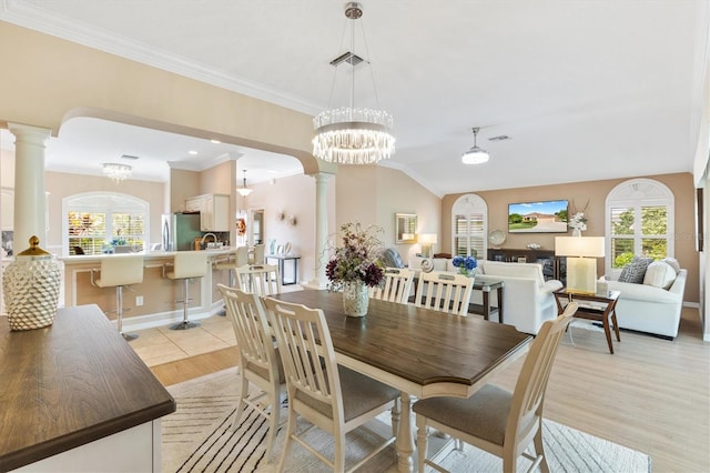 dining room with a wealth of natural light, light wood-type flooring, and decorative columns