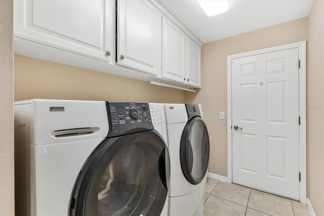 washroom with washer and dryer, light tile patterned flooring, and cabinets