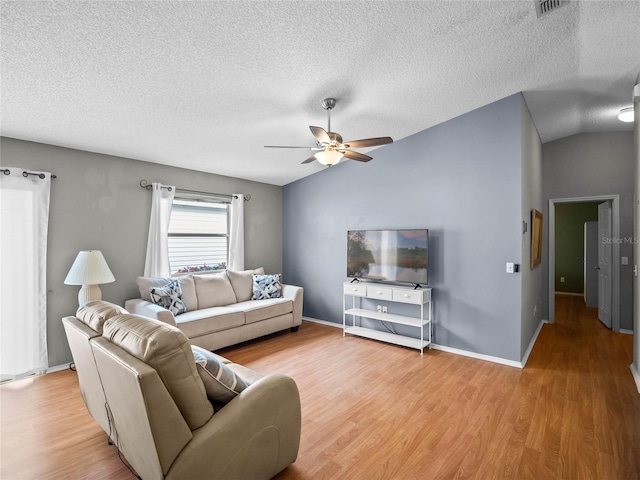 living room with a textured ceiling, hardwood / wood-style flooring, and vaulted ceiling