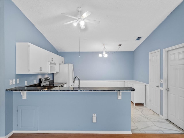 kitchen with kitchen peninsula, white cabinetry, ceiling fan with notable chandelier, and white appliances