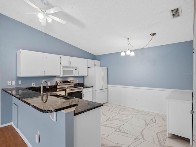 kitchen featuring kitchen peninsula, white cabinetry, hanging light fixtures, and white appliances