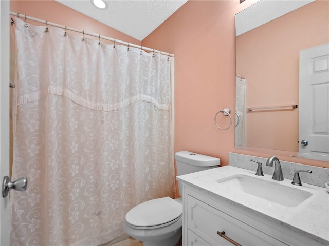 bathroom with a textured ceiling, vanity, lofted ceiling, and toilet