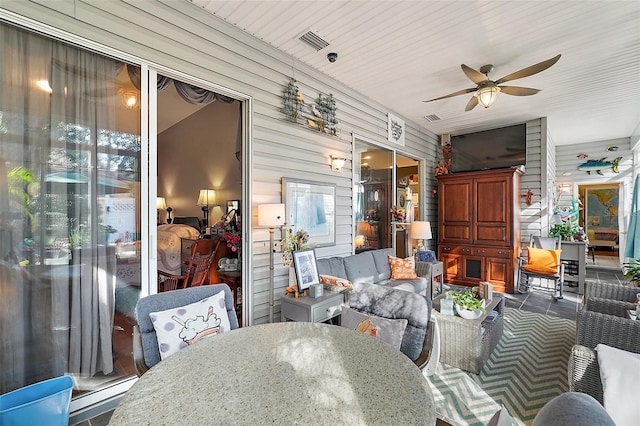 sunroom with ceiling fan and baseboard heating