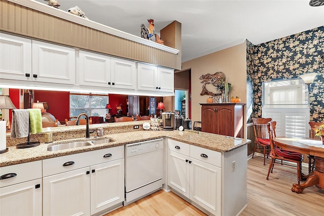 kitchen with dishwasher, light stone countertops, sink, white cabinetry, and kitchen peninsula