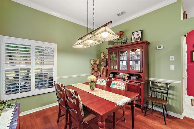 dining space featuring crown molding and dark hardwood / wood-style floors