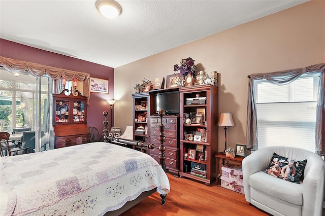 bedroom featuring hardwood / wood-style flooring and a textured ceiling