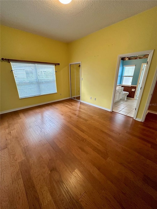 unfurnished room featuring light hardwood / wood-style flooring and a textured ceiling